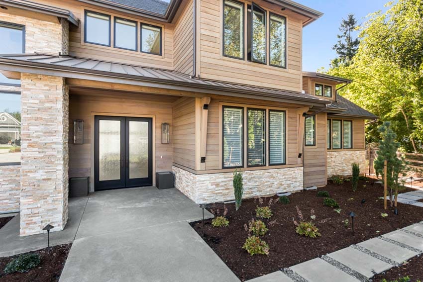 House exterior with walkway, wood siding, windows, and frosted glass front door