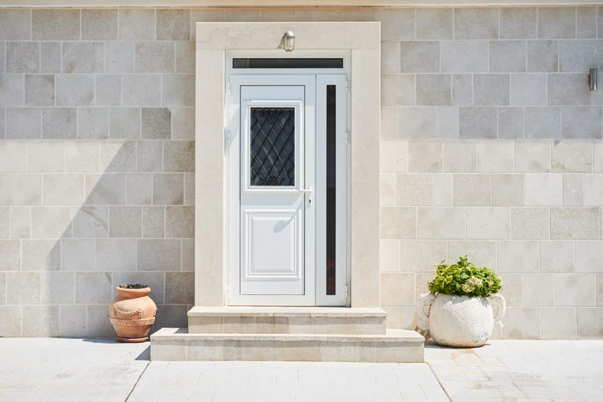House exterior with white frosted glass front door and tile wall cladding