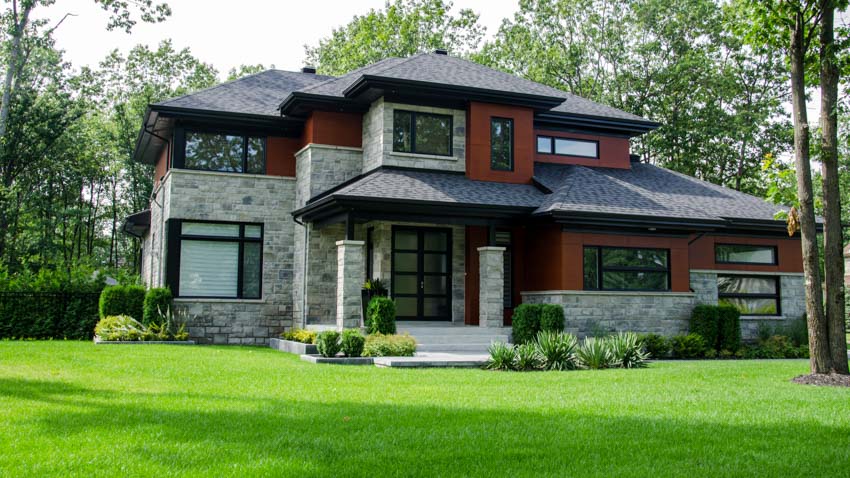 House exterior with windows, hedge plants, landscaped front lawn, and frosted glass front door