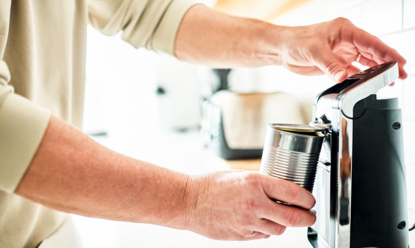 Individual using electric can opener