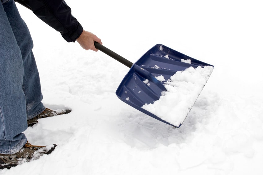 Individual using scoop shovel for snow