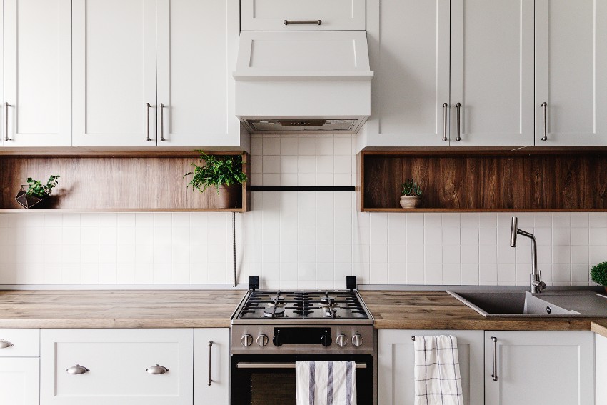 Kitchen cabinets with bookcase in Scandinavian style with steel oven, sink and wooden tabletop