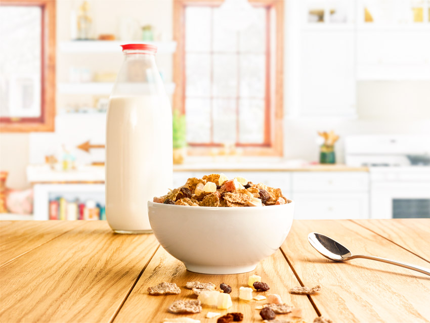 Kitchen table with cereal bowl, bottle of milk, and spoon