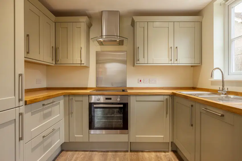Kitchen with MDF cabinets, wood floors, countertop, sink, faucet, and wood floors