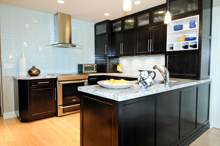 Kitchen with acid etched frosted glass cabinets, countertop, backsplash, range hood, and oven