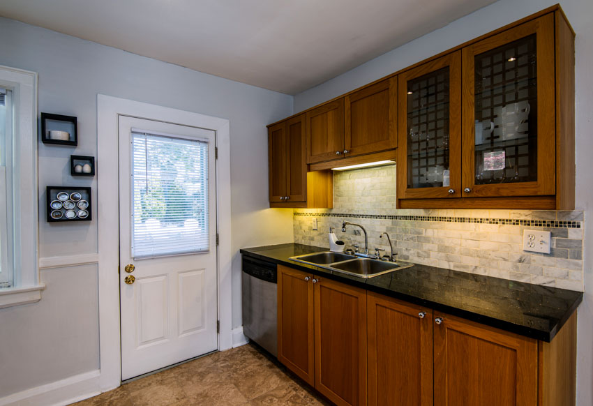 Kitchen with applied translucent film, frosted glass cabinets, countertop, backsplash, sink, faucet, and glass door