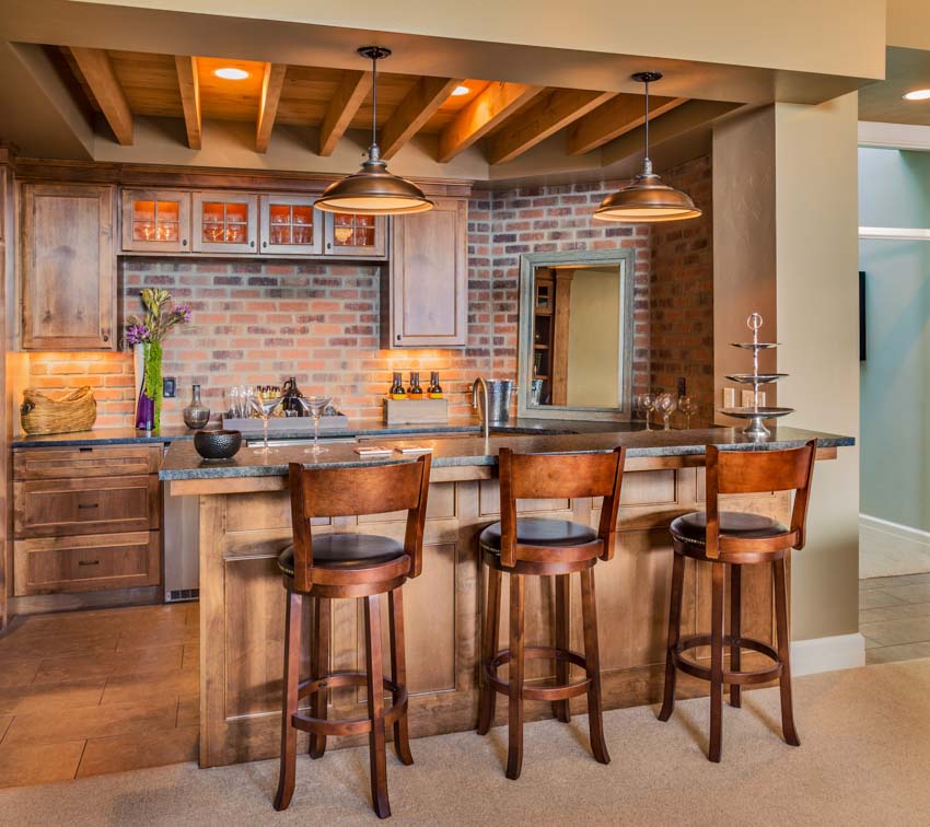Kitchen with bar counter, high chairs, brick tile backsplash, exposed wood ceiling beam, pendant lights, and countertop