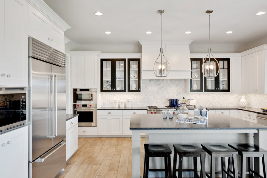 Kitchen with bar stools, island, dark countertop, and beautiful marble tile 