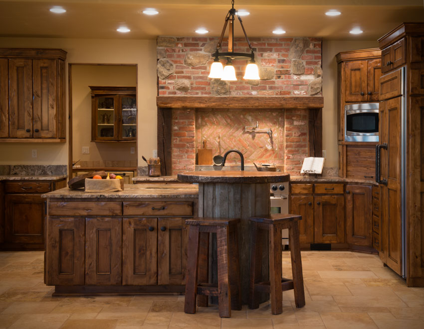 Kitchen with solid brick backsplash, island, wood cabinets, ceiling lights, chandelier, and oven