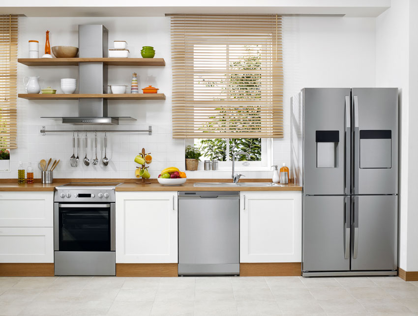 Kitchen with built-in dishwasher, oven, countertop, shelves, range hood, countertop, refrigerator, and window