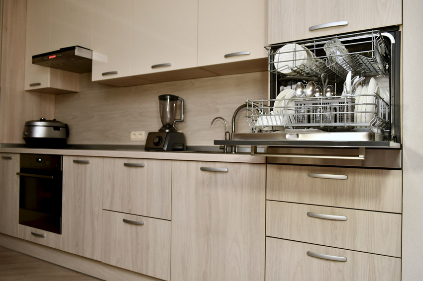 Kitchen with cabinets, backsplash, oven, and dishwasher