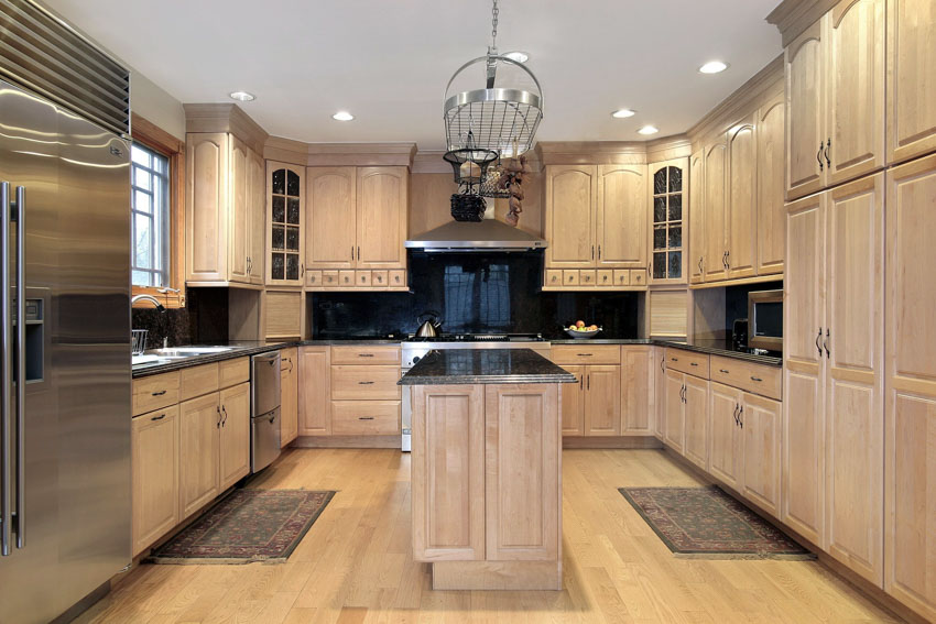 Kitchen with different hardware for oak cabinets, chandelier, island, countertops, backsplash, window, and refrigerator
