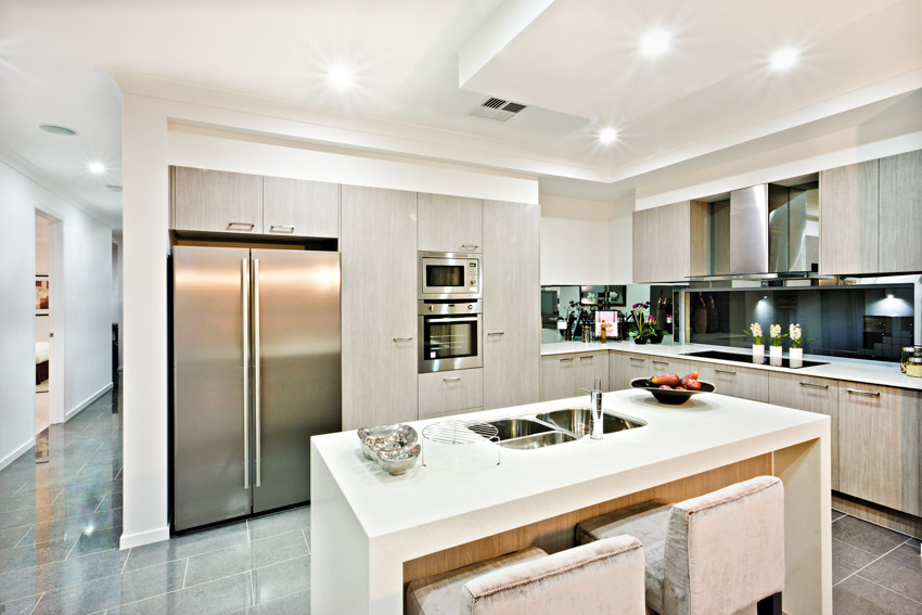 Kitchen with island, chairs, countertop, refrigerator, glazed porcelain tile floor, backsplash, range hood, and cabinets