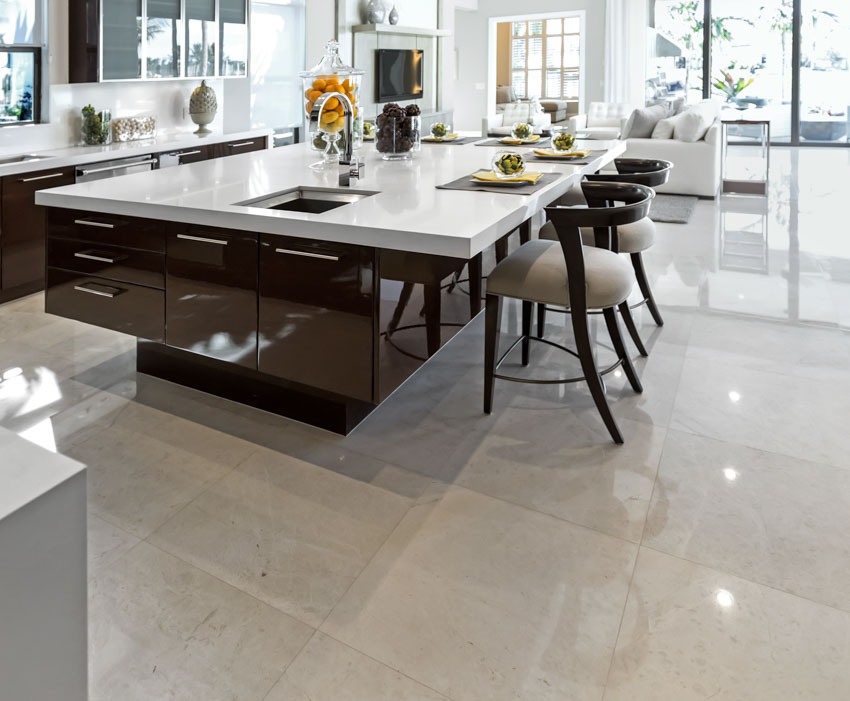 Kitchen with island, countertop, chairs, cabinets, sink, chairs, and glazed porcelain tile