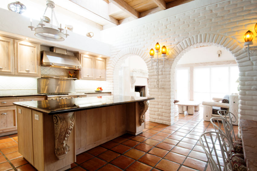 Kitchen with island, tile flooring and white brick walls
