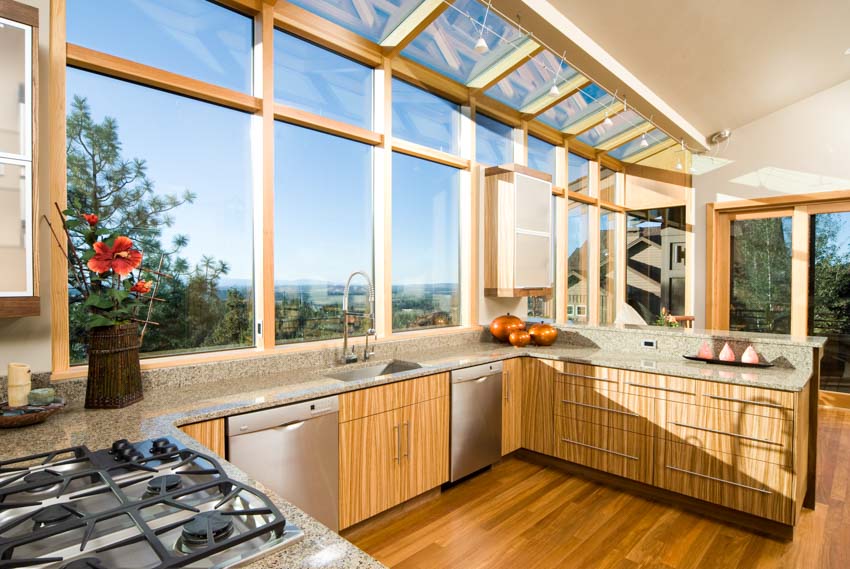 Kitchen with wood grain laminate cabinet, wraparound windows and granite counters