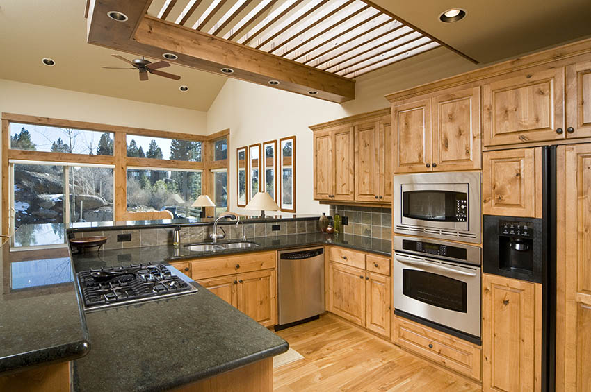 Kitchen with natural knotty wood cabinets black granite countertops