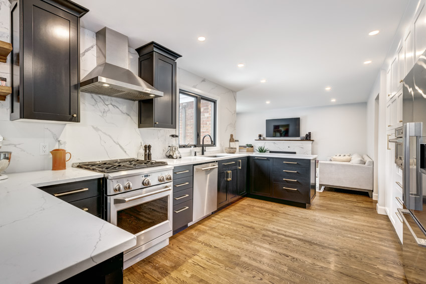 Porcelain slab backsplash, U-shaped kitchen and black and white color combination for the cabinets