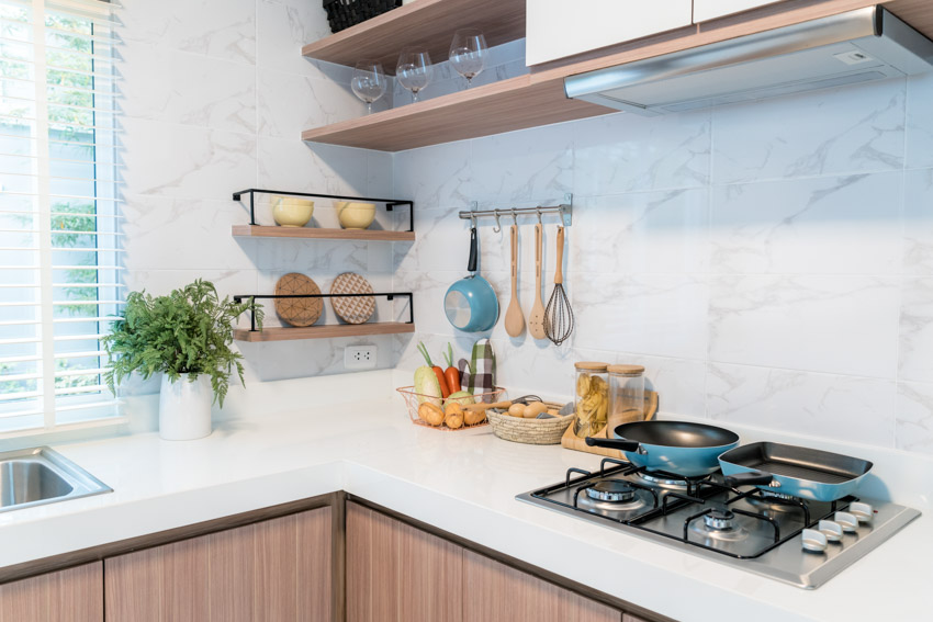 Kitchen with open shelves with wine glasses and hooks with small pot