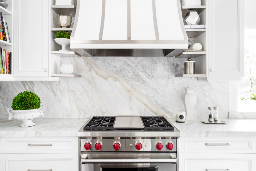 Kitchen withWhite hoot, marble look backspalsh and kitchen table taop accessories