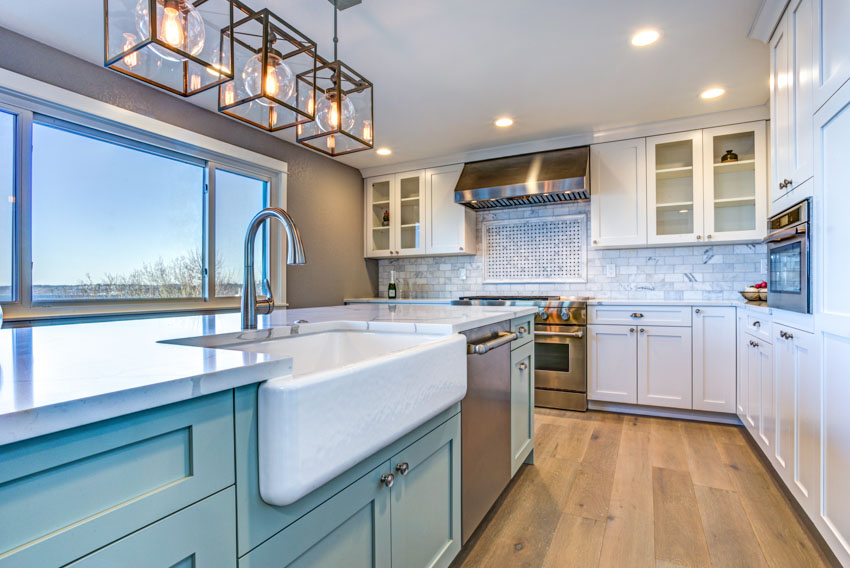 Kitchen with porcelain subway tile, porcelain sink, square chandelier, and picture windows