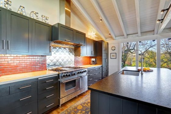Kitchen With Red Brick Backsplash Black Cabinets Range Hood Countertop Stove Oven And Island Ss 561x374 