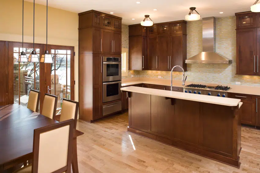 Kitchen with solid wood cabinets, countertop, island, wood flooring, and ceiling lights
