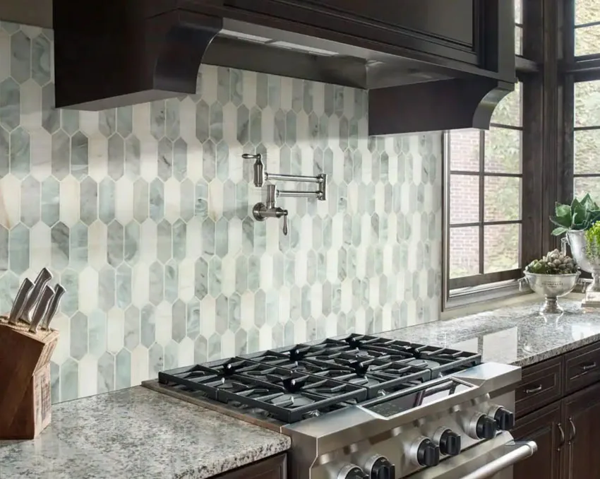 Kitchen with stove, granite countertop, and marble backsplash