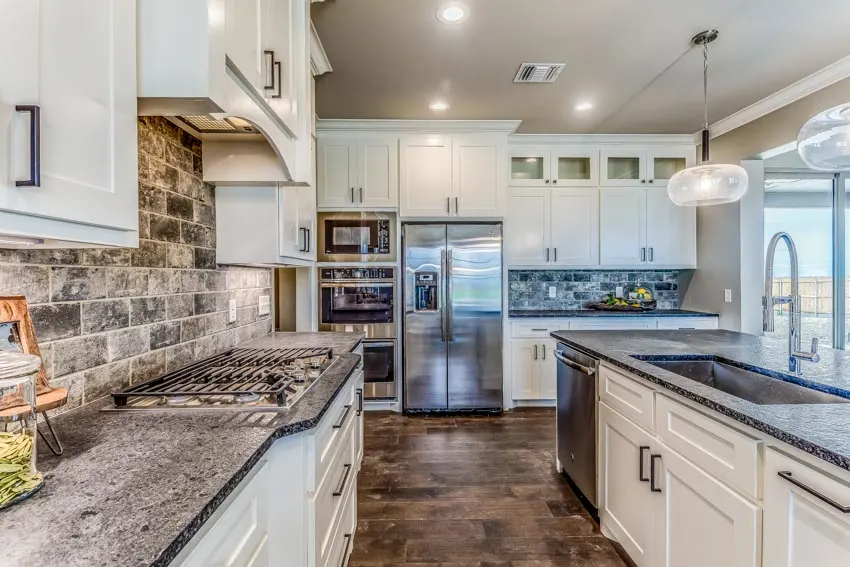 Kitchen with tile backsplash and gray speckled granite