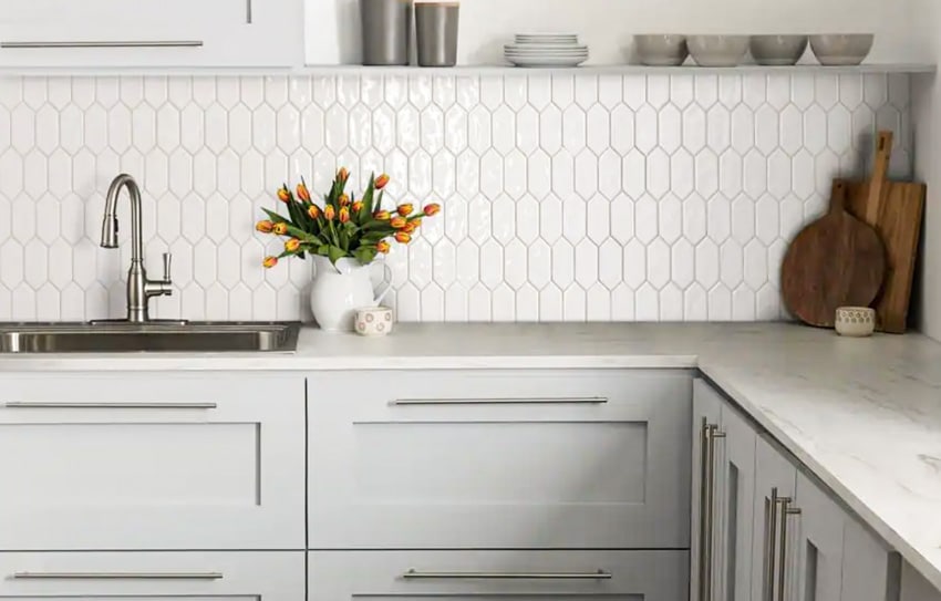 Kitchen with vertical picket tile backsplash, sink, faucet, and countertops