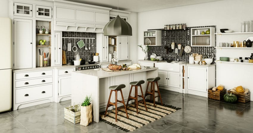 Kitchen with vertical subway tile backsplash, island, bar stools, white cabinets, range hood, stove, and floor mat