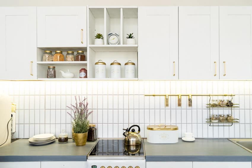 Kitchen with solid surface countertop, white tiles and gold design accents