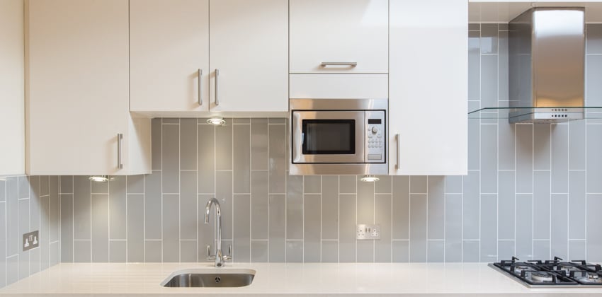 Countertop with faucet and small sink, backsplash and cabinets