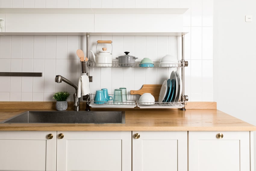 Kitchen with wood laminate countertop, dish rack and mugs
