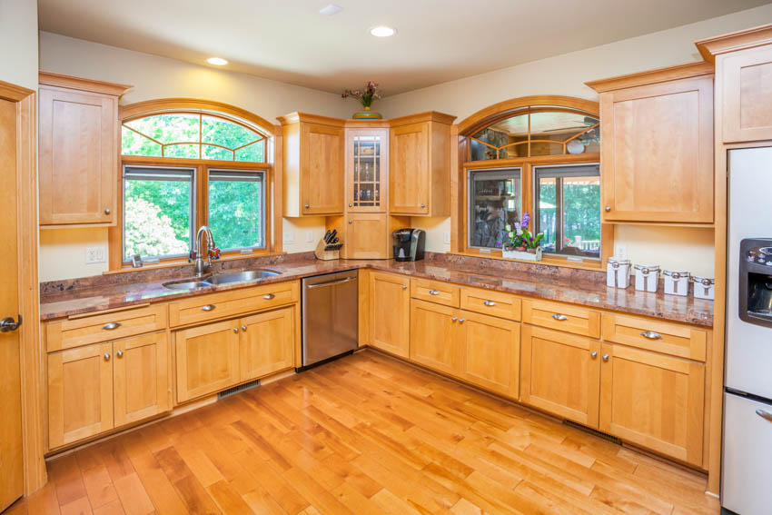 Kitchen with wood floors, melamine cabinets, ceiling lights, and windows