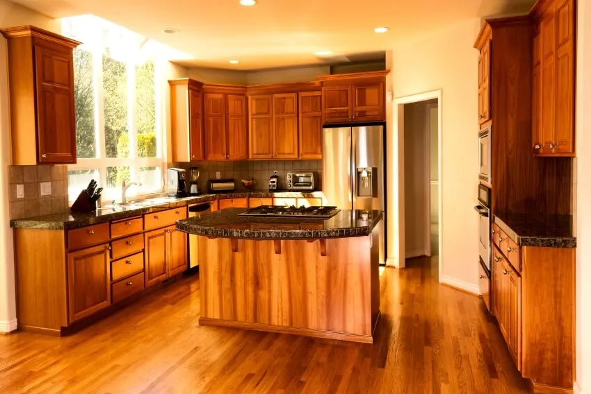 Large kitchen with stainless steel appliances, hardwood floor, and rustic birch cabinets
