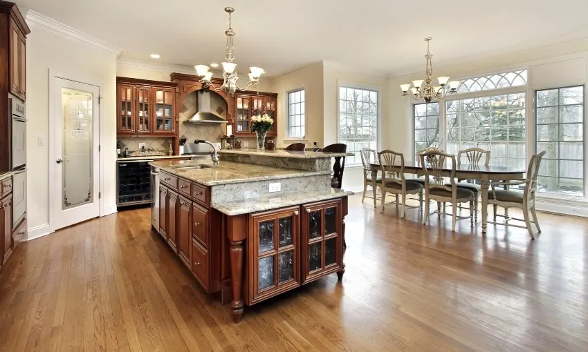 Large open dining and kitchen room with arts and crafts cabinets hardware and chandeliers