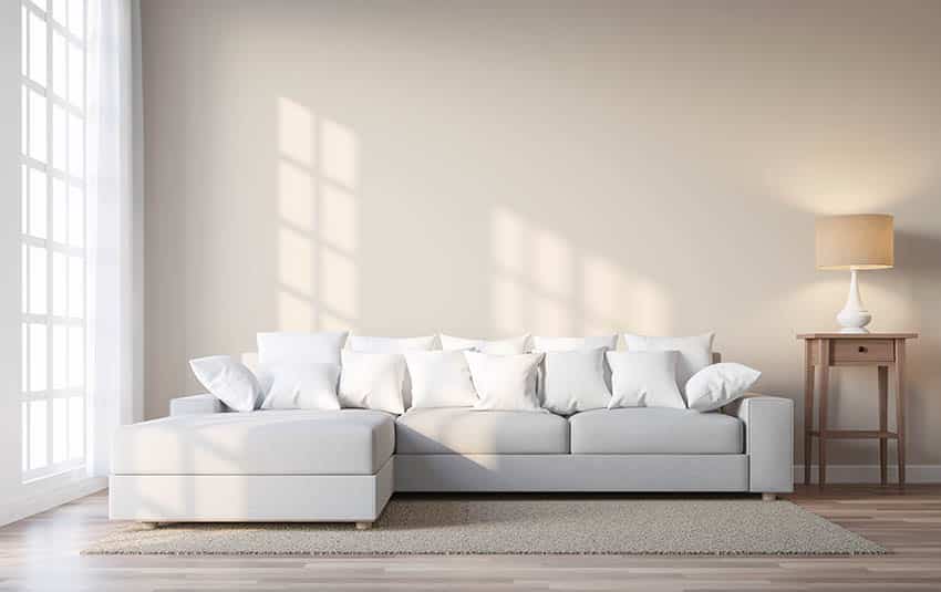 Living room with light grey sectional sofa beige painted walls