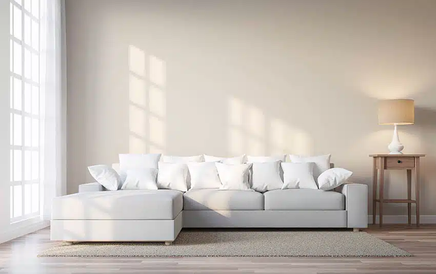 Room with light grey sectional sofa and beige painted walls