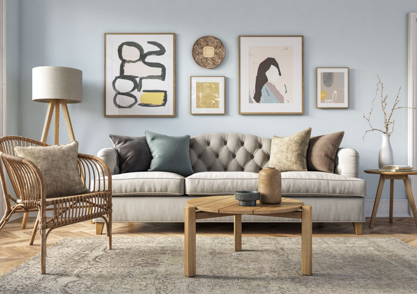 Living room with taupe couch, floor lamp, chair, coffee table, pillows, and rug