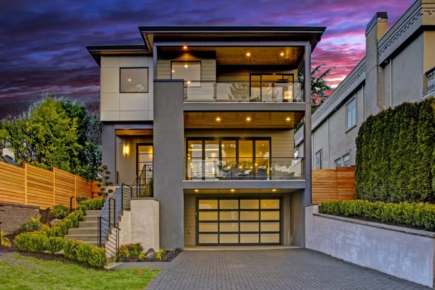 Luxurious home exterior with stairs leading to the entrance and full frosted window garage door