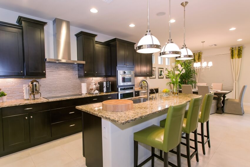 Luxurious kitchen with pendant lights, glass tile backsplash, and brown granite countertops