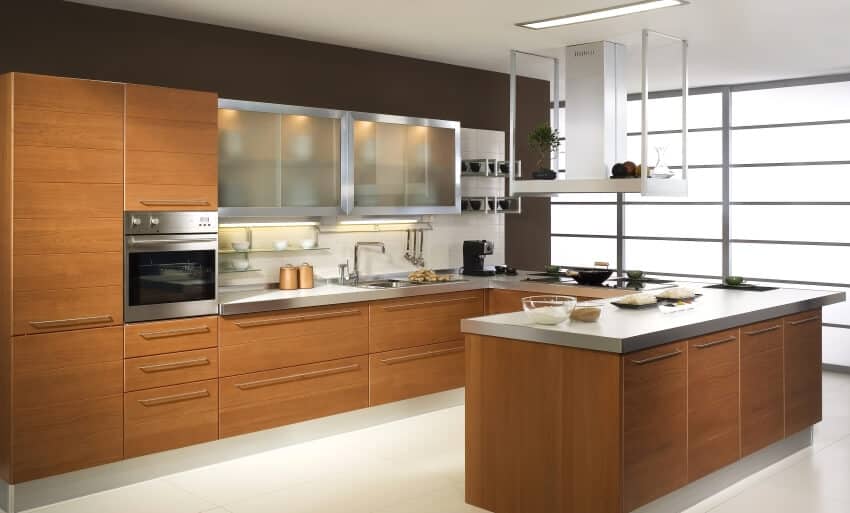 Luxurious kitchen with wood and aluminum cabinets and cook top with exhaust hood with shelf