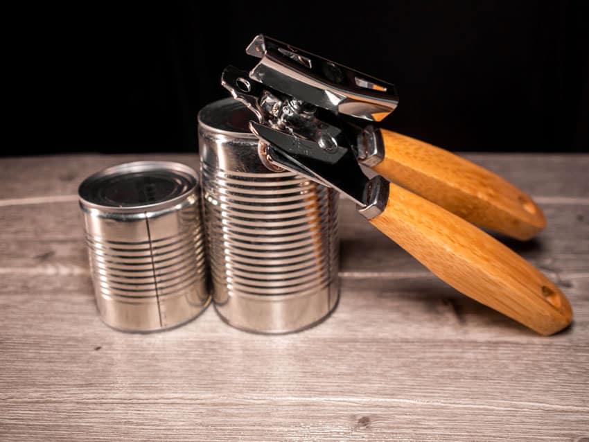 Metal cans and a can opener for kitchens