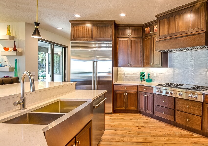 Mid century modern style kitchen with hardwood flooring, rich brown wood cabinets and granite countertops with undermount sinks