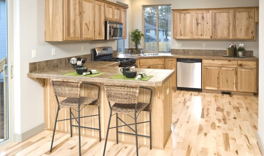 Modern cedar cabinets, tile countertops, and chairs in a classic kitchen