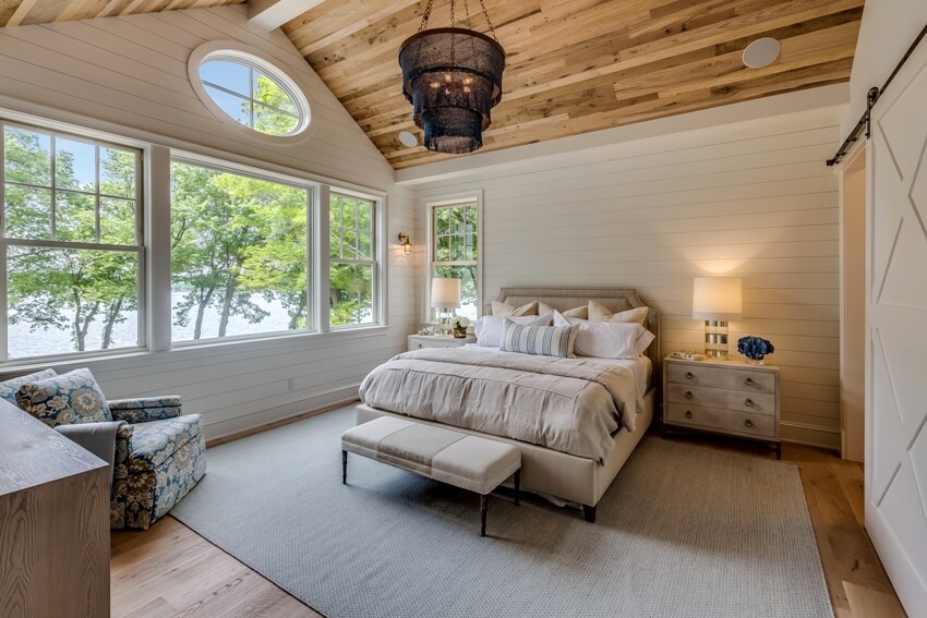 Bedroom with wooden floors, shiplap walls and bed