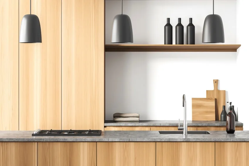 Modern kitchen interior with black decors on shelves, pendant lights, and modern birch cabinets