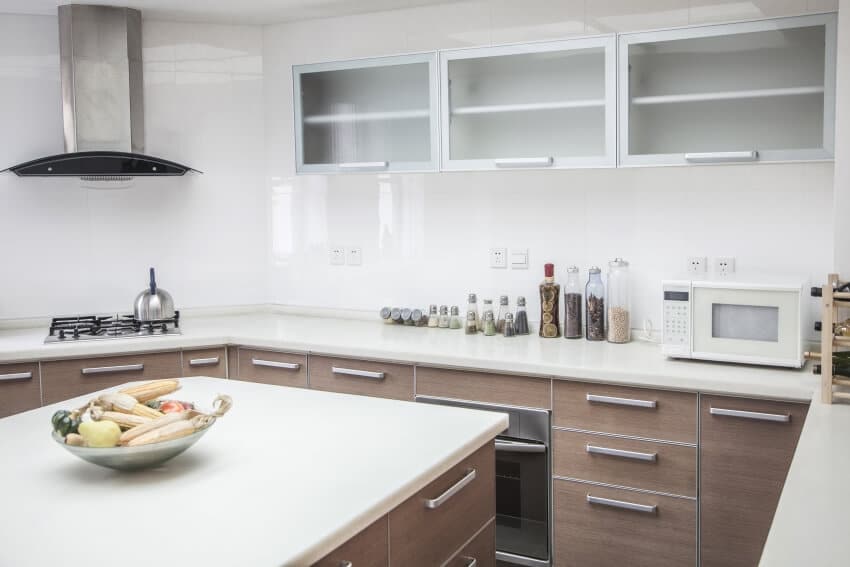 Modern kitchen with aluminum cabinets, tile backsplash, and white granite countertops
