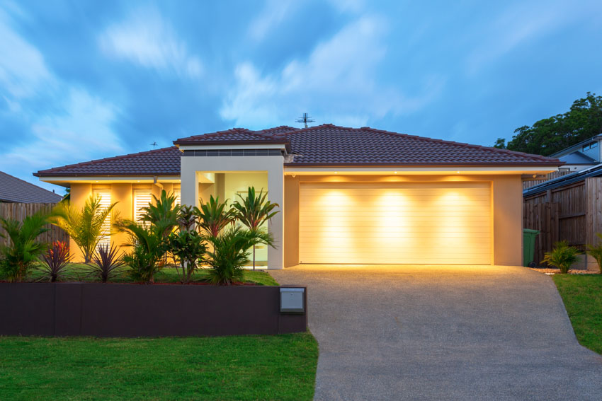 Modern ranch with driveway, landscape lighting and lawn